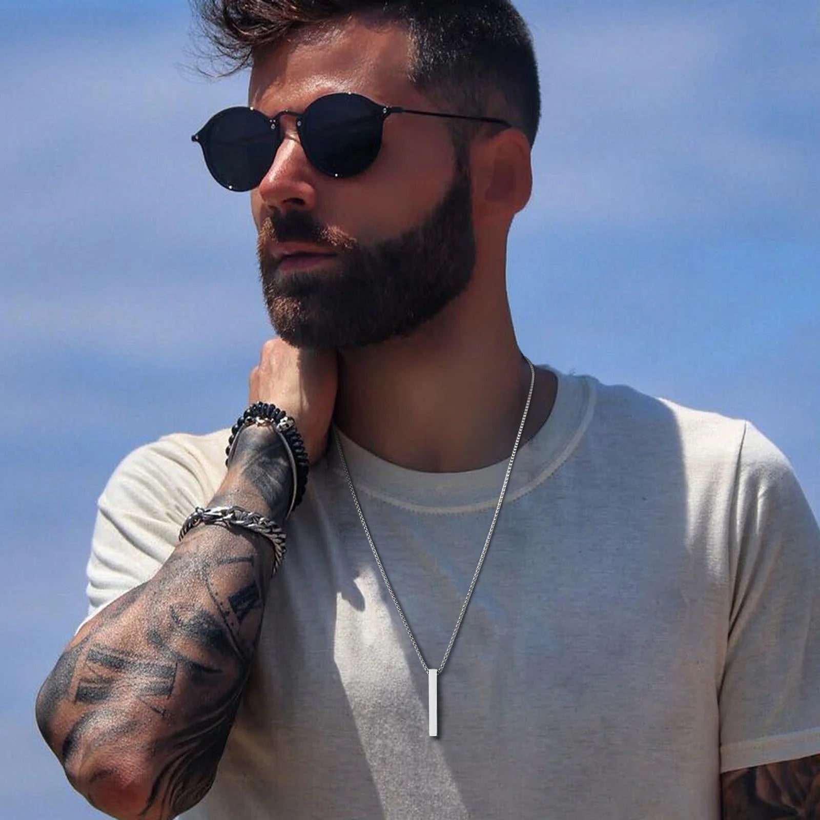Man wearing sunglasses and black pendant necklace, lifestyle photo